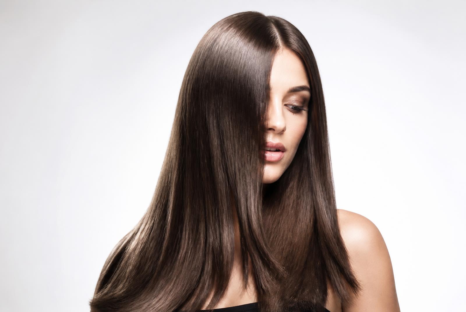 Glossy corrected brunette hair on a light studio background at a Utah salon