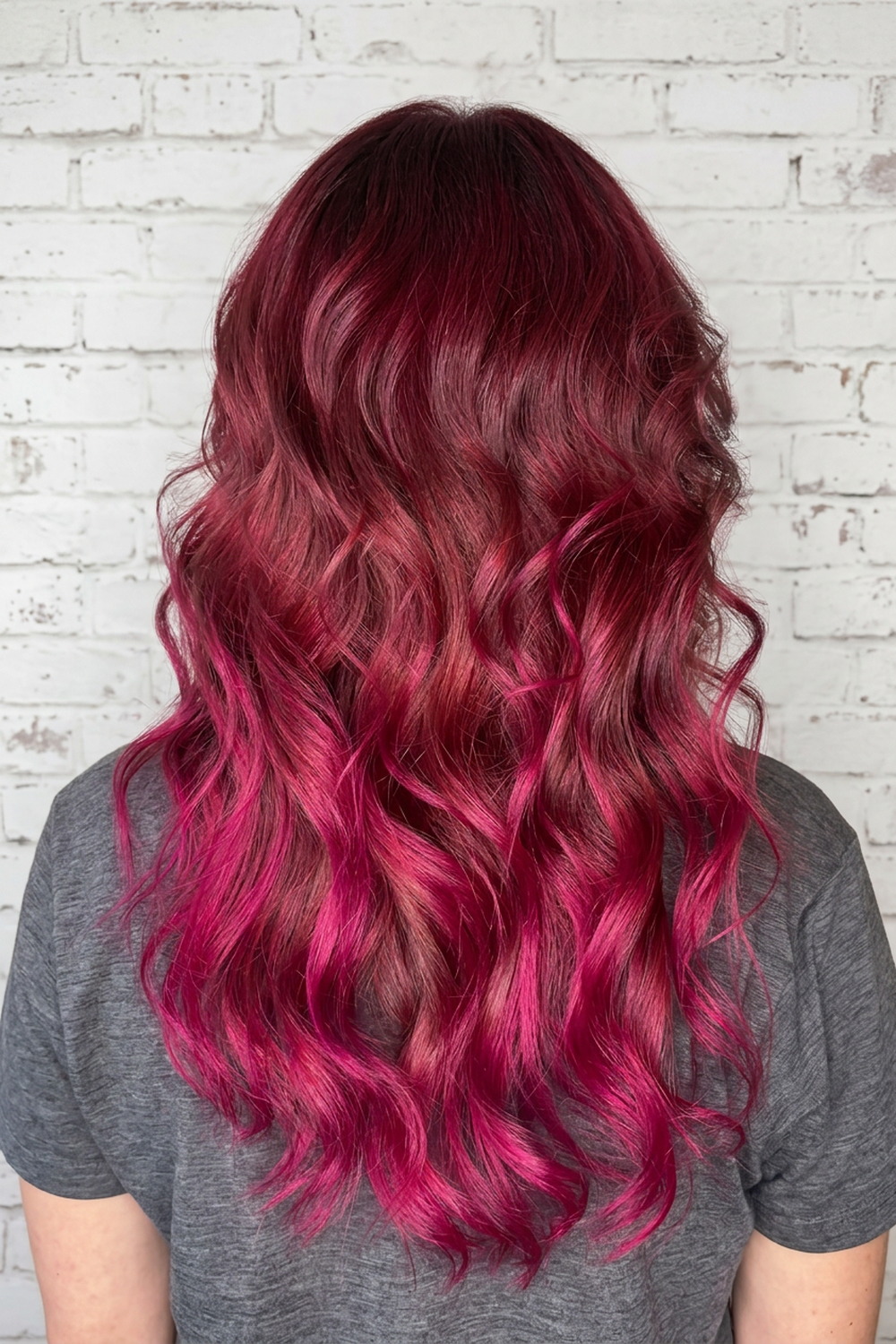 Vivid magenta and berry-pink hair color on long waves by Wicked Hair in Draper, Utah.