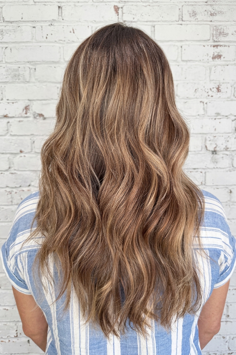 Dimensional brunette with caramel balayage highlights on long waves, Wicked Hair Draper.