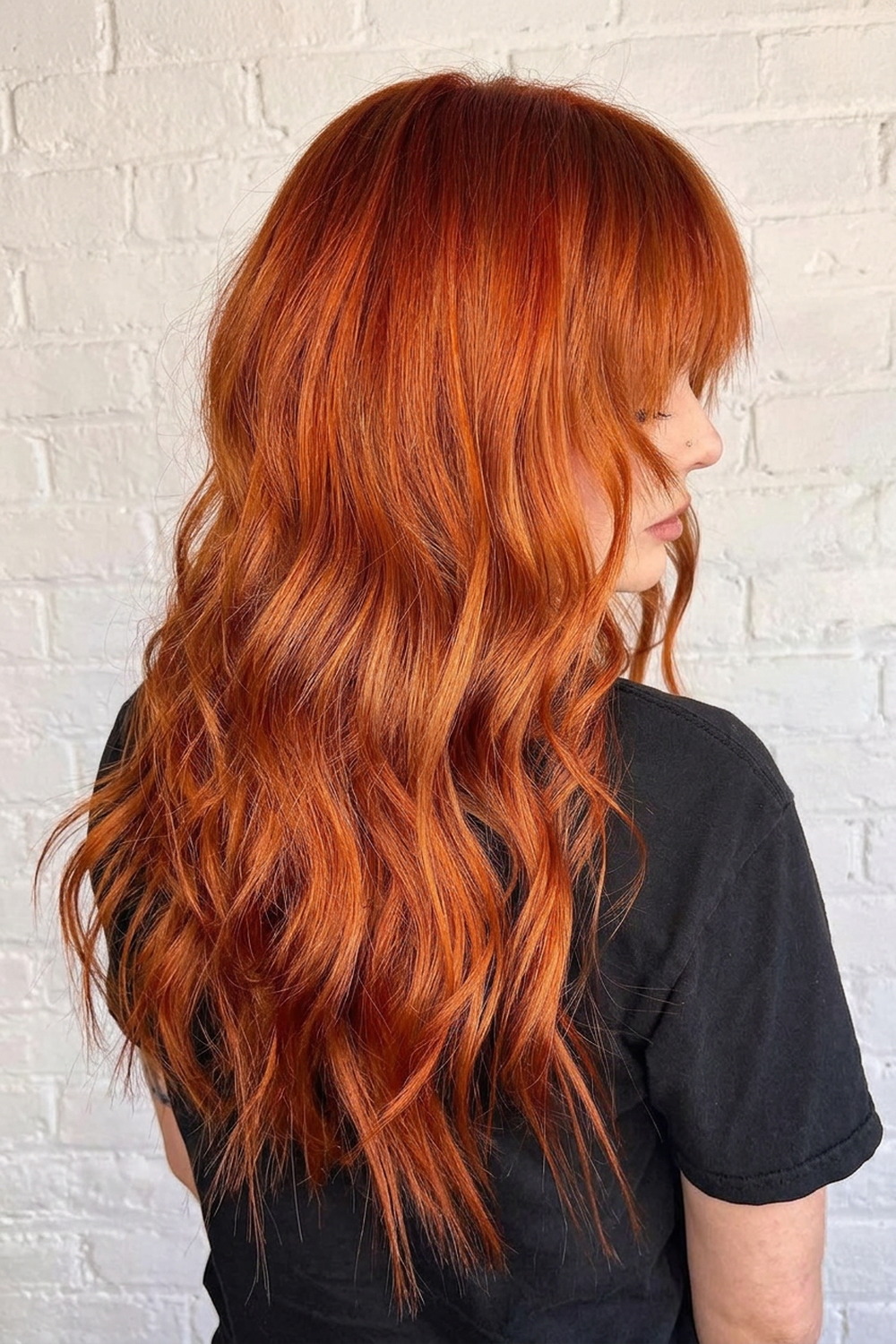 Bright copper hair color on a wavy shag with a fringe, Utah red hair color specialist Laila Grigley.