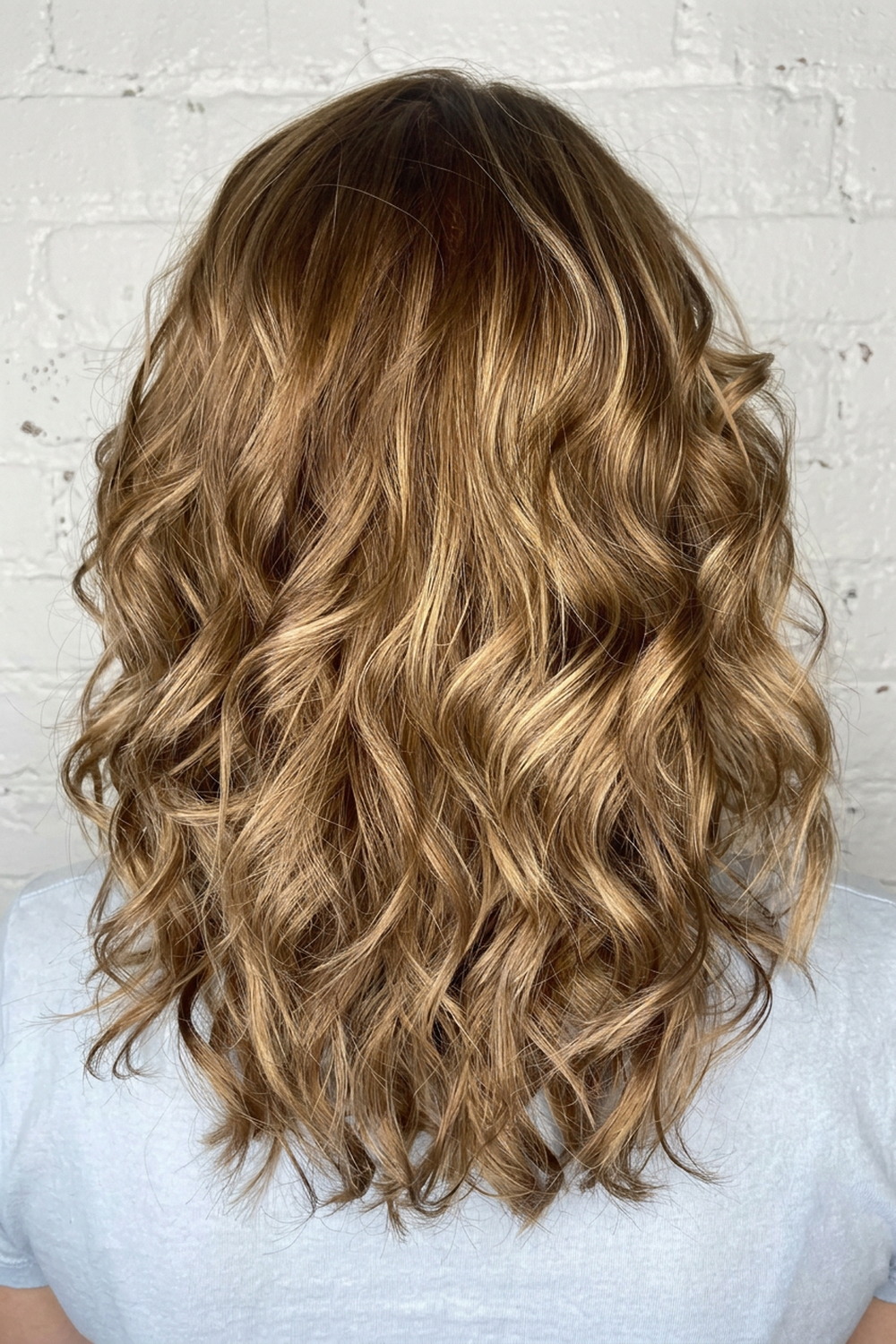 Honey golden blonde waves with fine highlights, warm blonde colour by Laila Grigley in Utah.